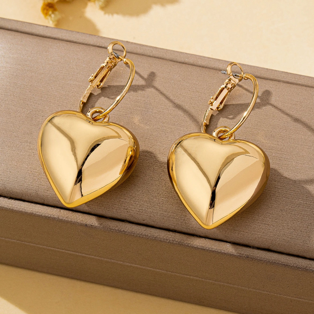 Un par de pendientes de moda para mujer en forma de corazón liso, oro - plata