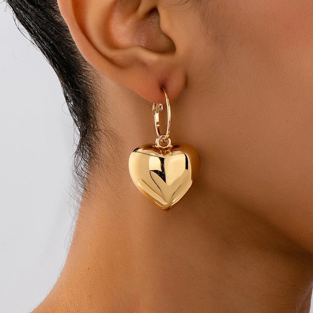 Un par de pendientes de moda para mujer en forma de corazón liso, oro - plata