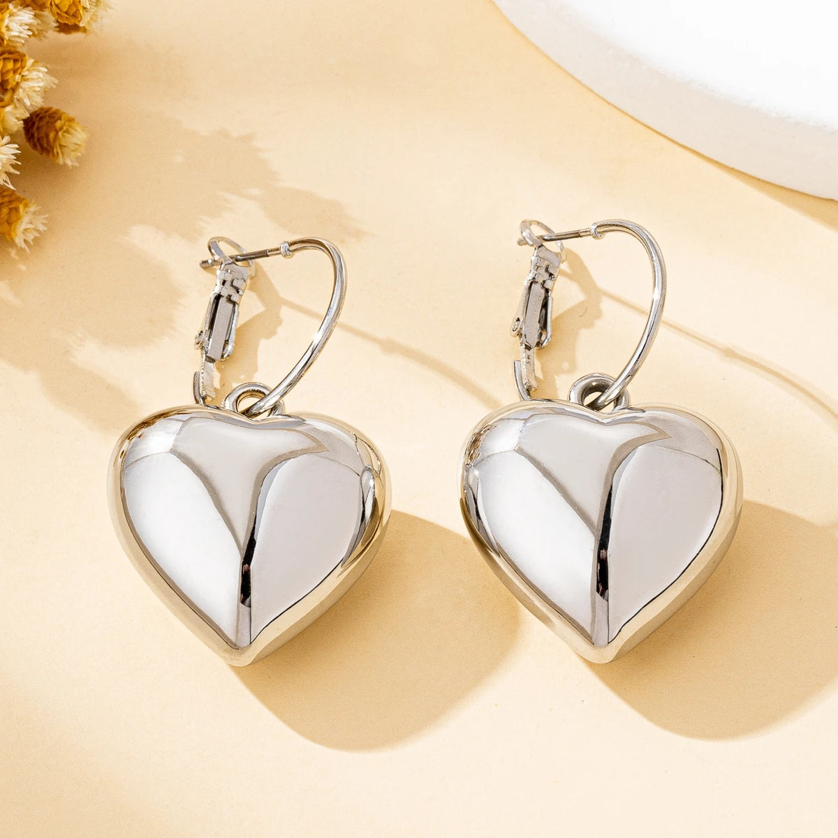 Un par de pendientes de moda para mujer en forma de corazón liso, oro - plata