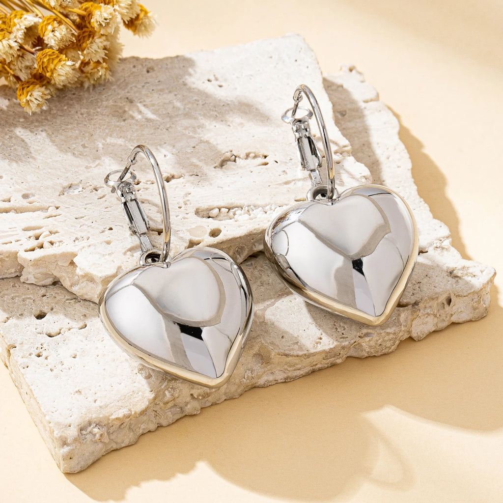 Un par de pendientes de moda para mujer en forma de corazón liso, oro - plata
